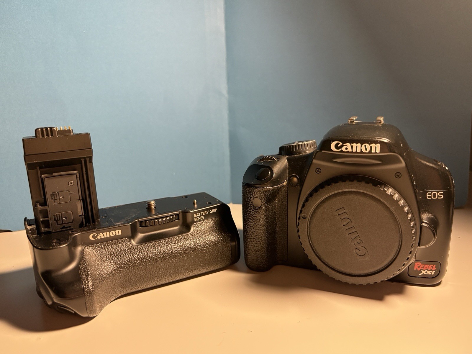 Canon Rebel XSI DSLR Camera With Battery Grip BG-E5, Strap, Charger, Body Cap.